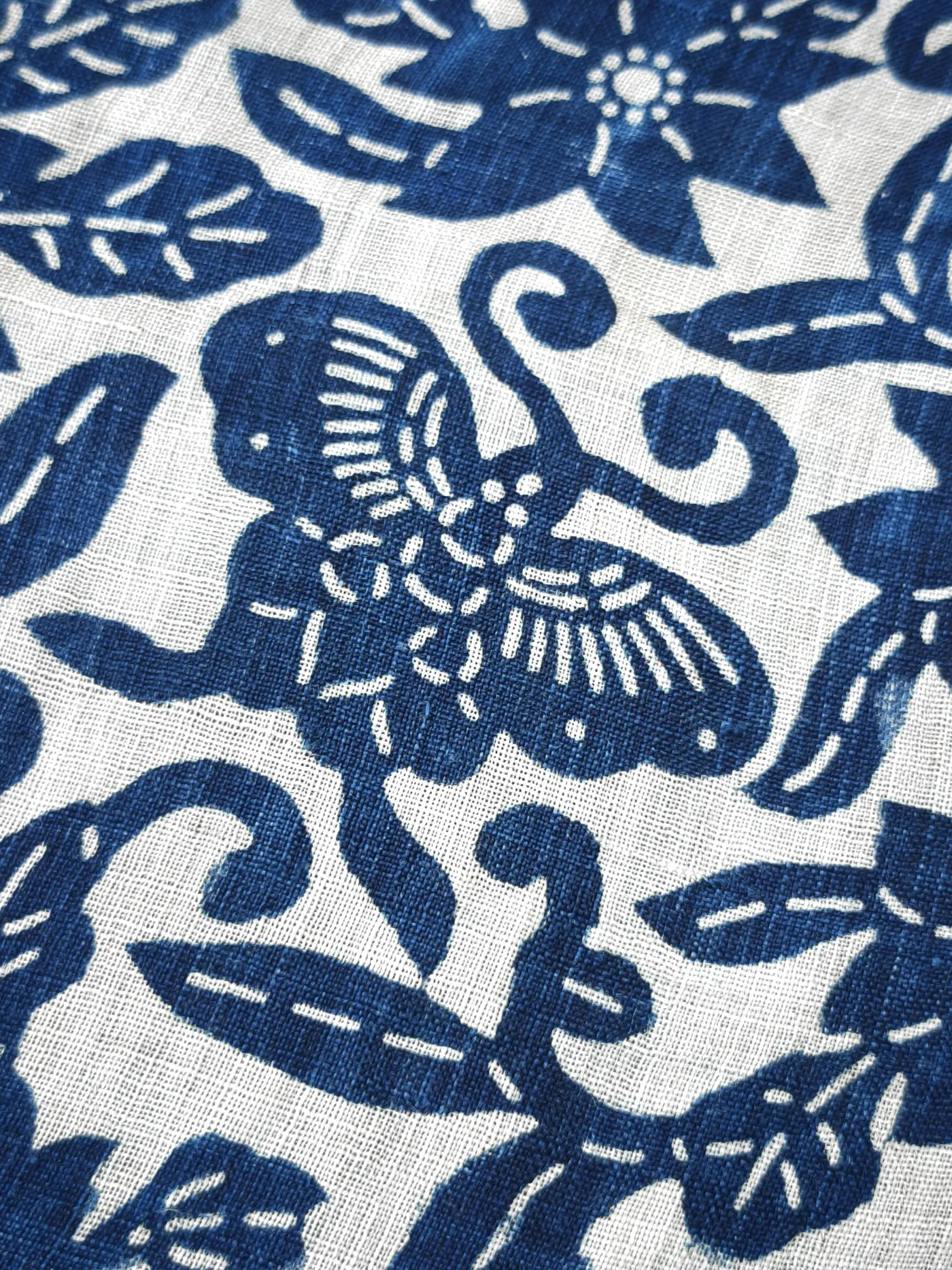 Second close detail of the same blue-and-white butterfly and floral cloth.