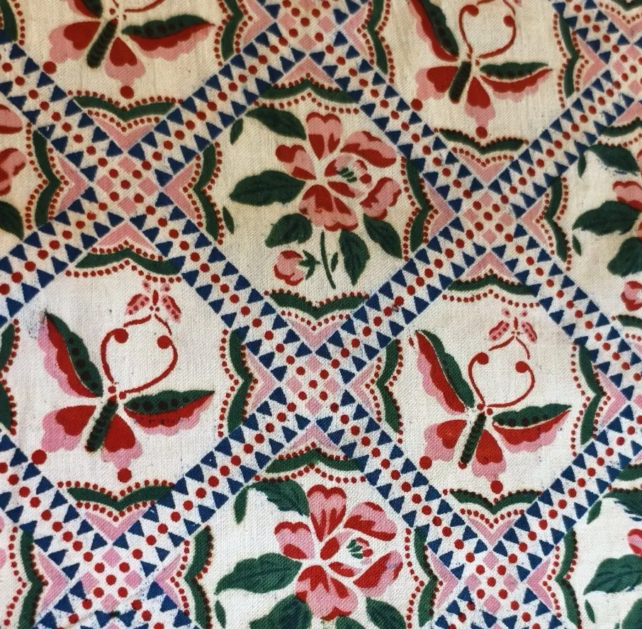Multicolour repeat alternating a butterfly with pink floral motifs inside geometric frames.