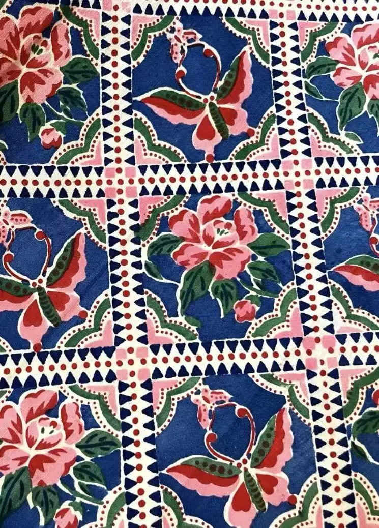 Wider view of the same multicolour geometric butterfly-and-flower repeat.