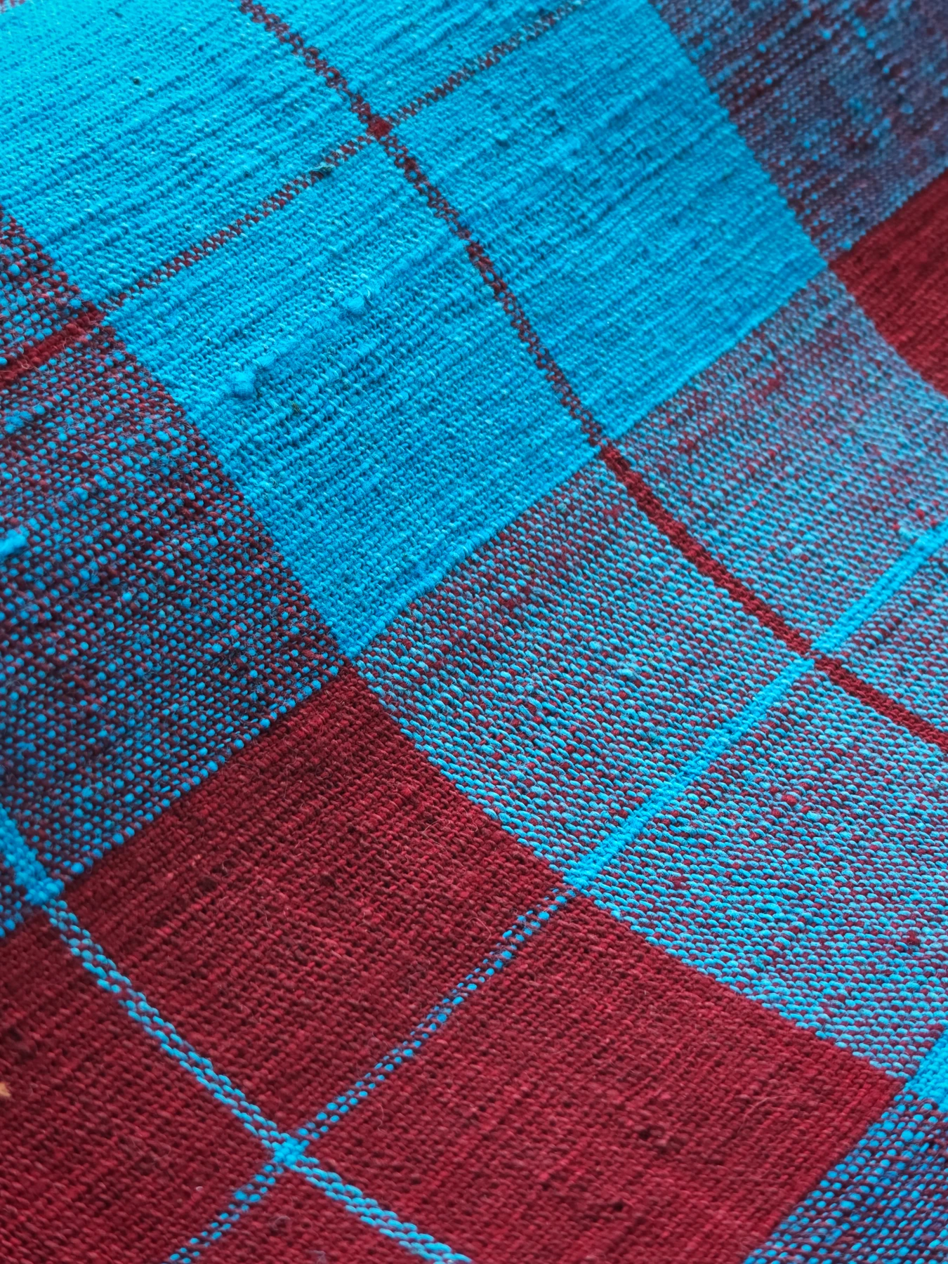 Close view of Crimson Lake Plaid, showing textured lake-blue yarn and crimson checks.