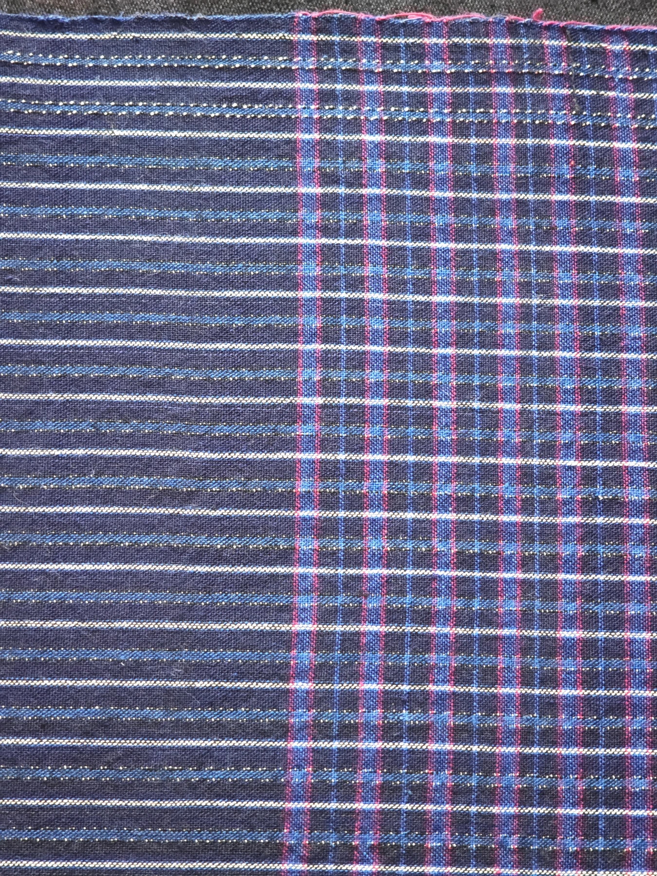A photographed transition between stripe and check sections in the same continuous cloth.